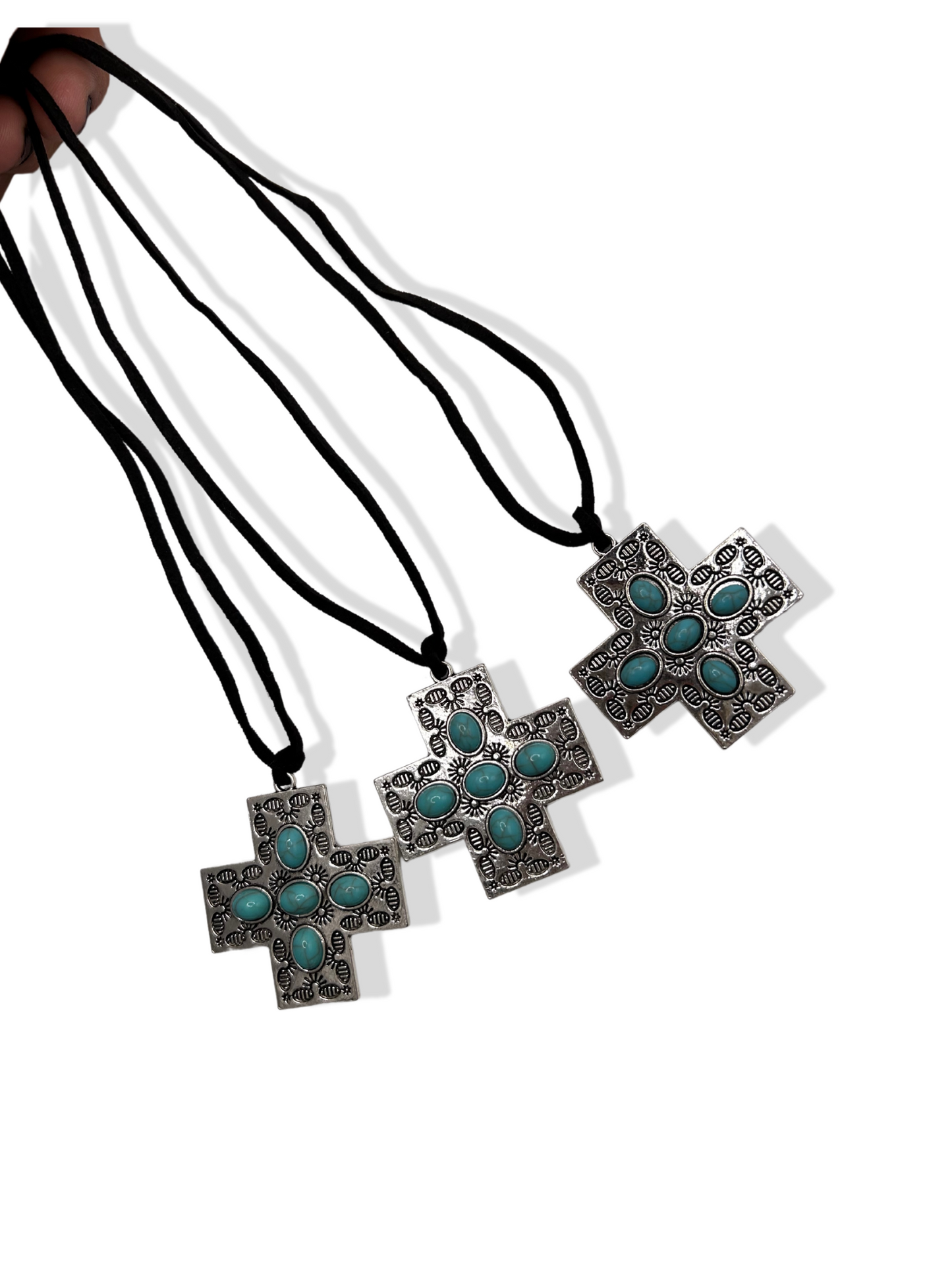 Three of the same necklaces. Large stainless steel engraved crosses with turquoise stones on black suede cord chains
