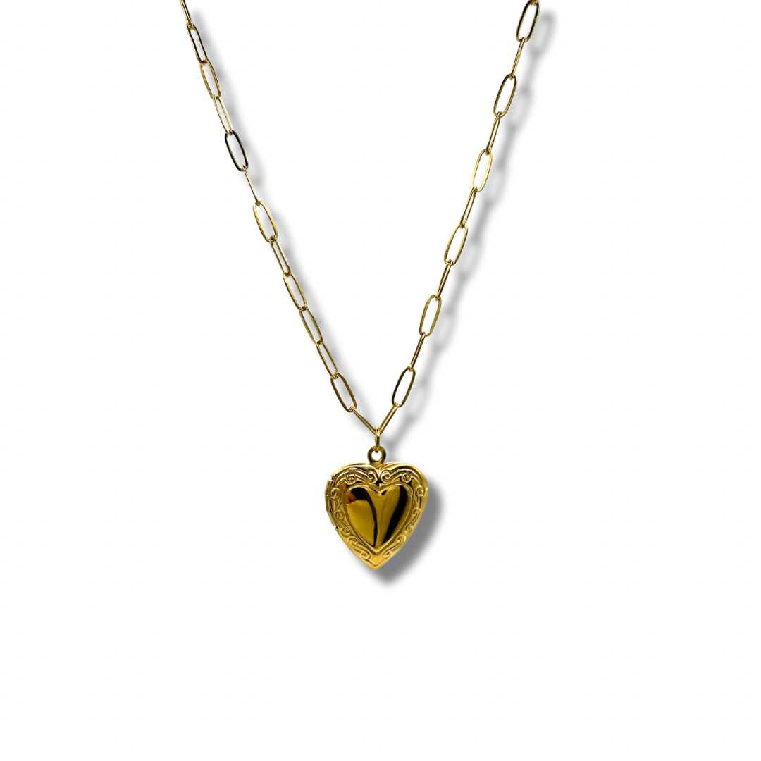 a dainty gold chain with a detailed heart shaped locket pendant