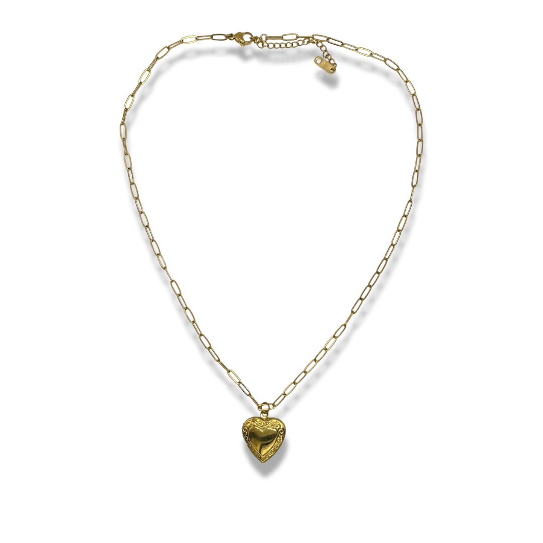 a dainty gold chain with a detailed heart shaped locket pendant