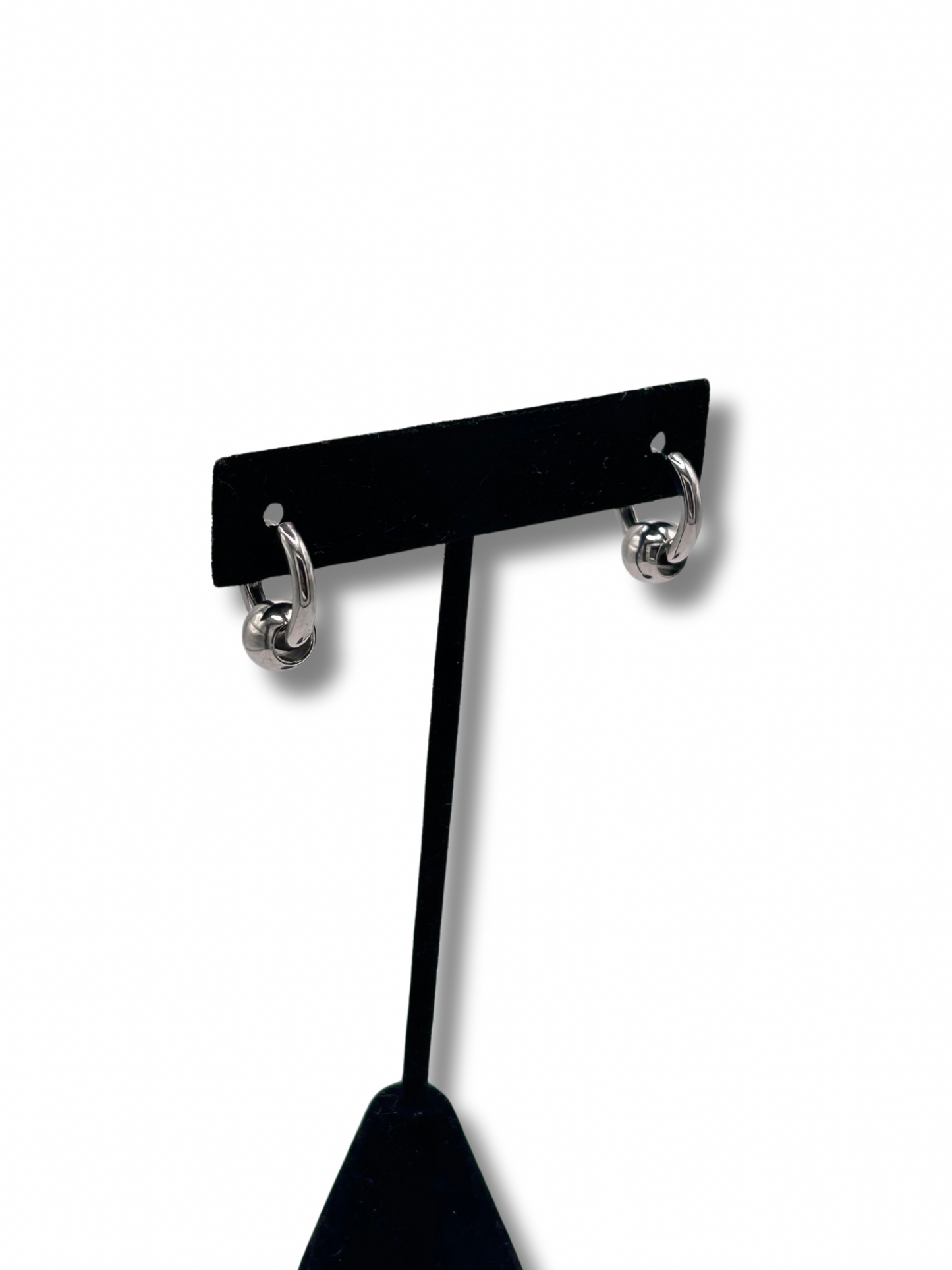 2 earrings hanging on a jewellery stand featuring a metallic infinity ball piercing style