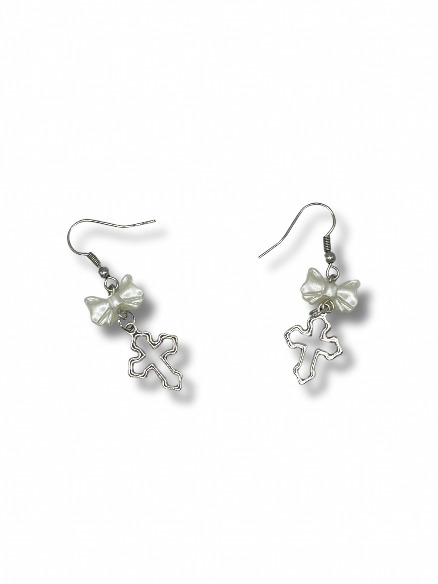 2 earrings featuring white pearl bows with a hanging silver cross under them