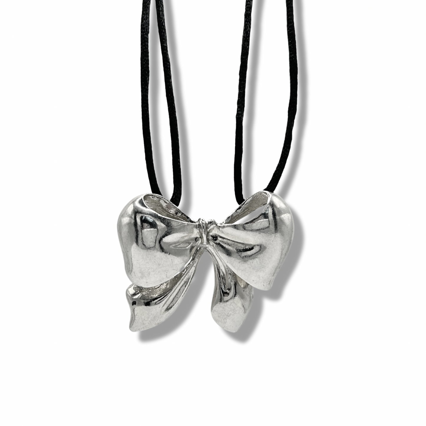 a close up shot of a chunky bow necklace on a black suede chain