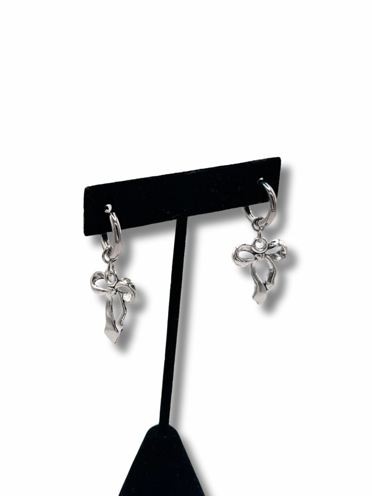 2 silver bow earrings hanging off a jewellery stand