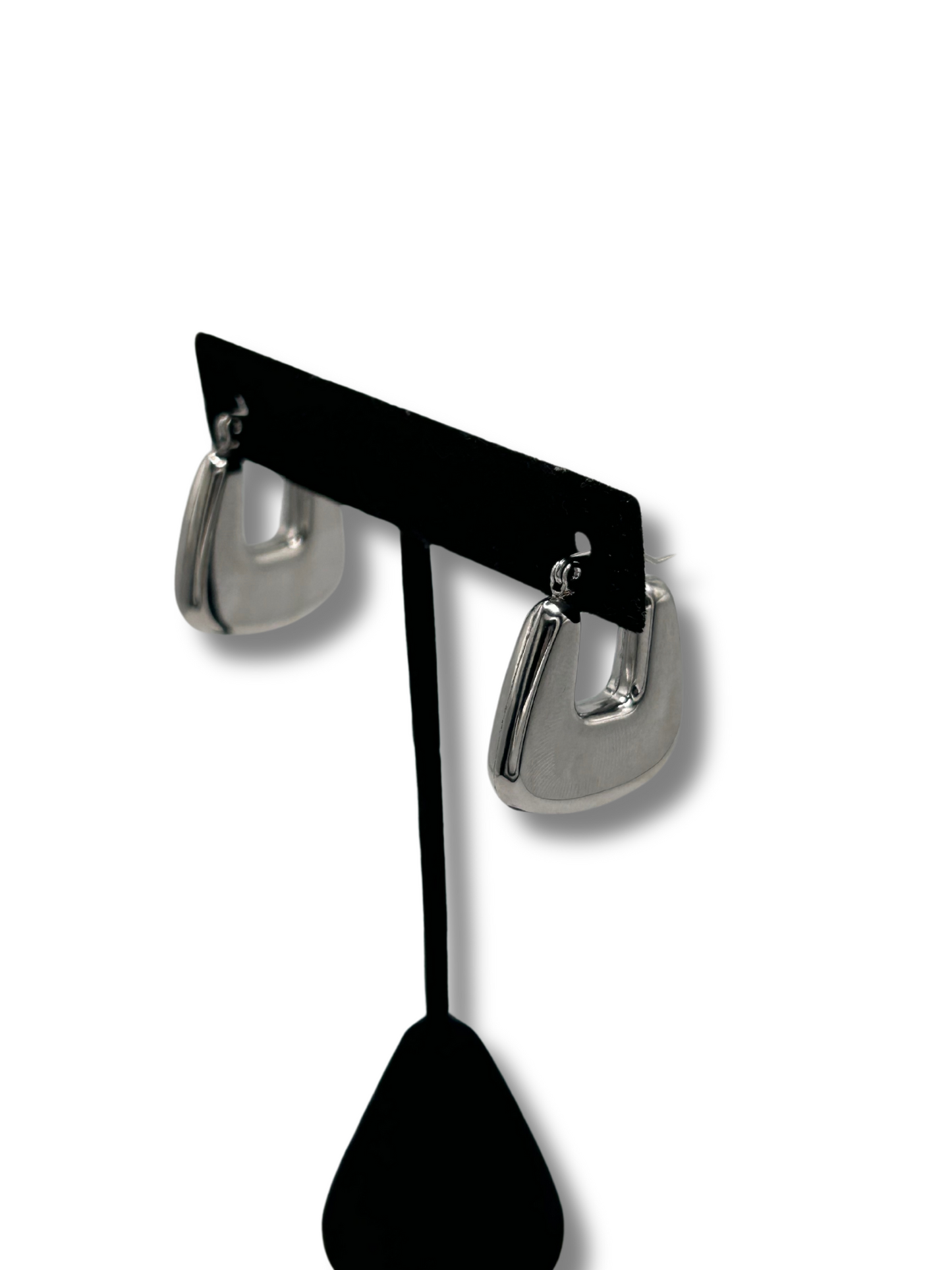 a pair of chunky silver earrings hanging off a jewellery stand