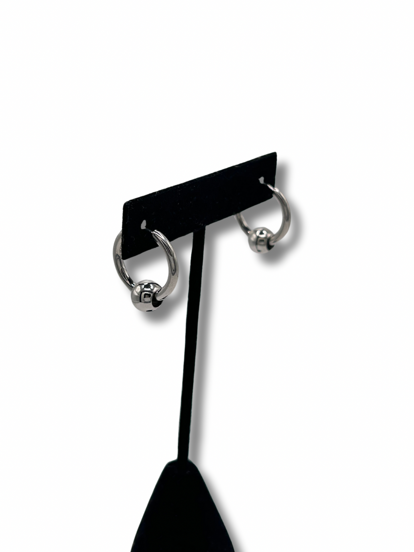 2 earrings hanging on a jewellery stand featuring a metallic infinity ball piercing style