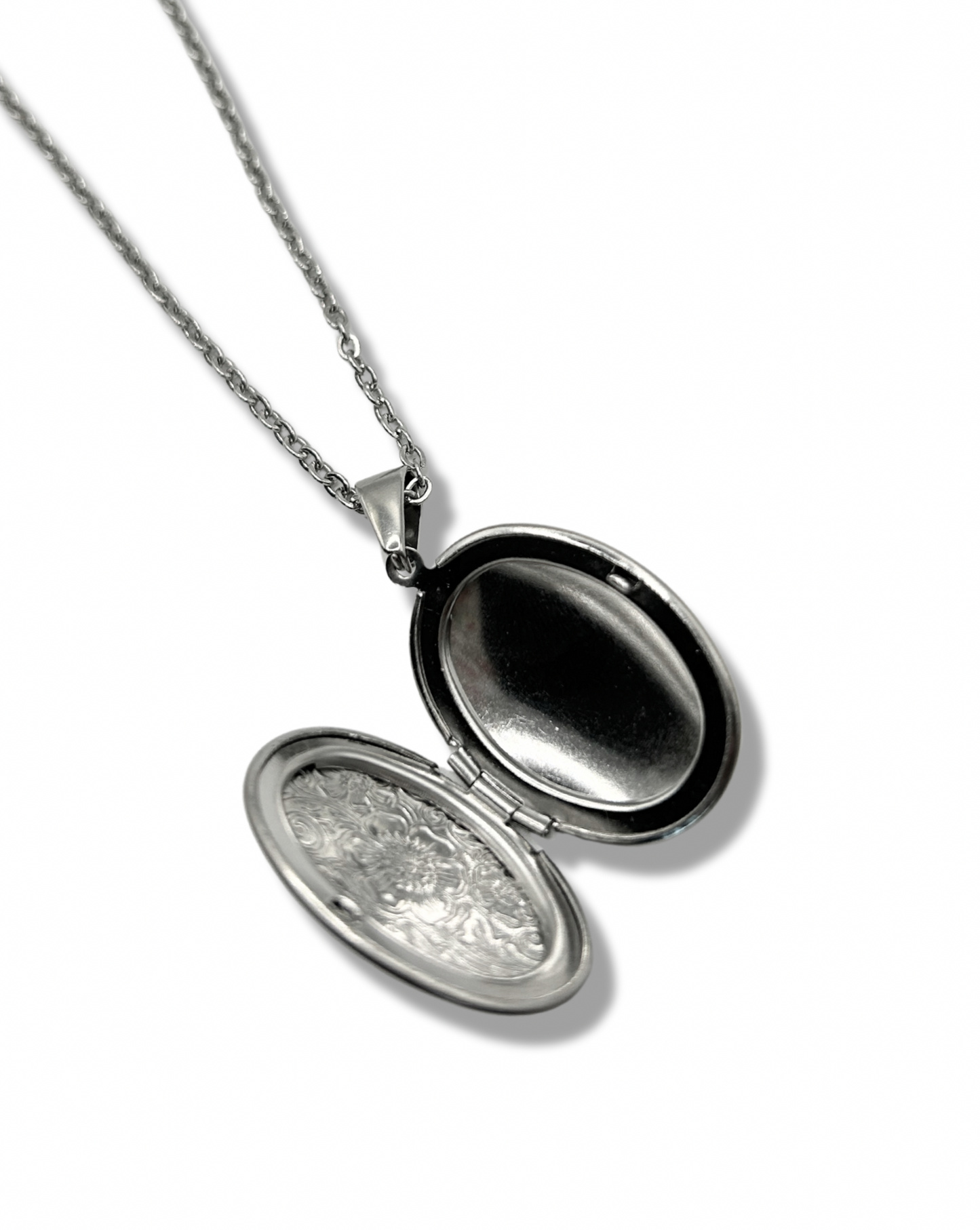 a close up shot of an open floral oval shaped locket pendant