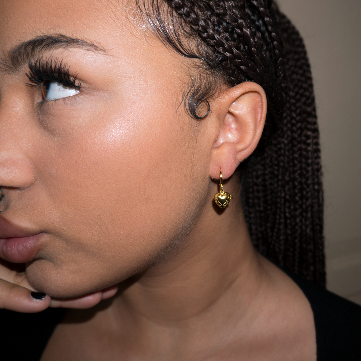 Girl wearing gold heart pendant locket earrings