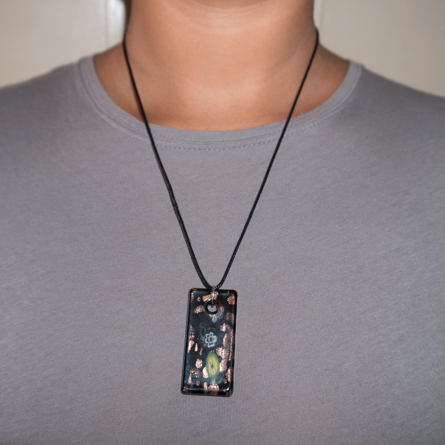 Model wearing floral style monolith pendant necklace, with details of coloured flowers