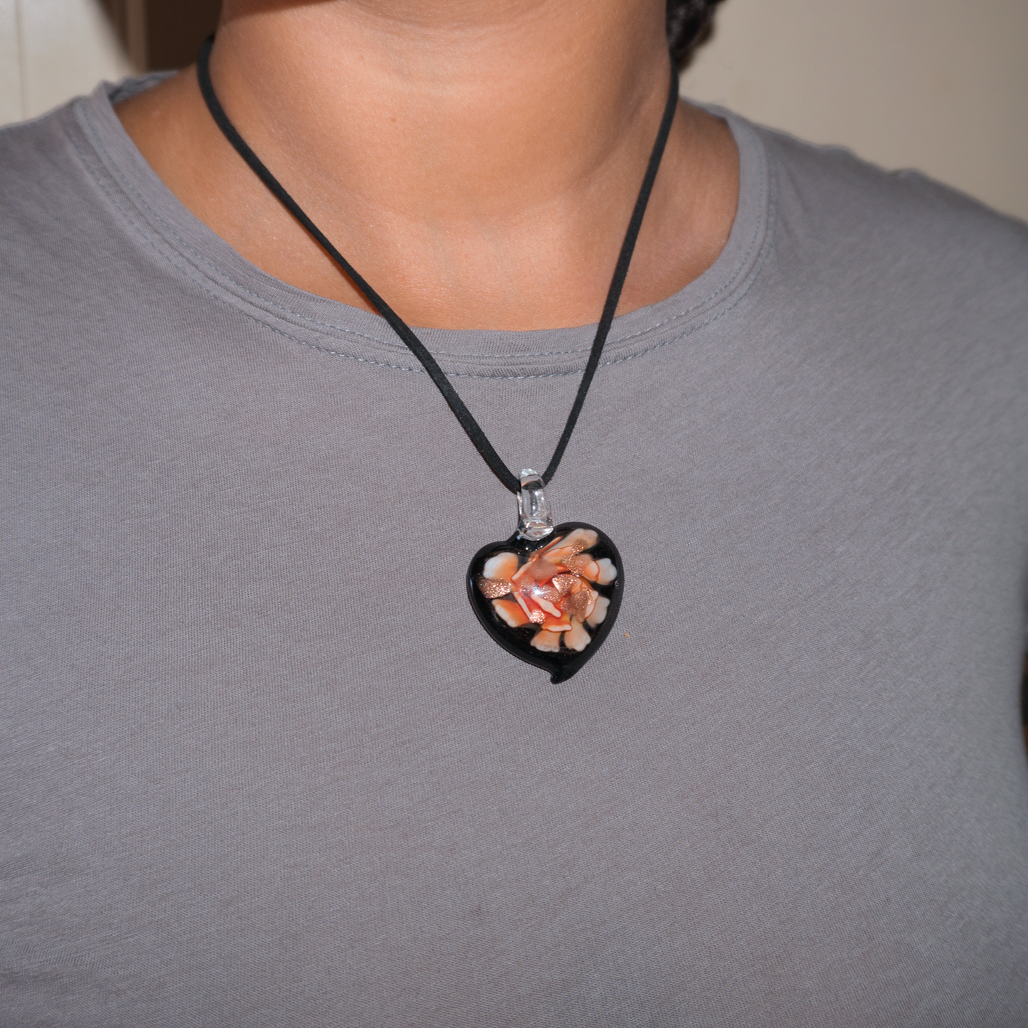 Model wearing a black love heart necklace with pink floral details