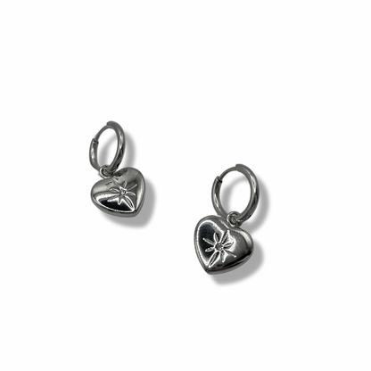 small huggie hoops with a heart pendant. on the heart pendant is an engraved star and rhinestone in the centre
