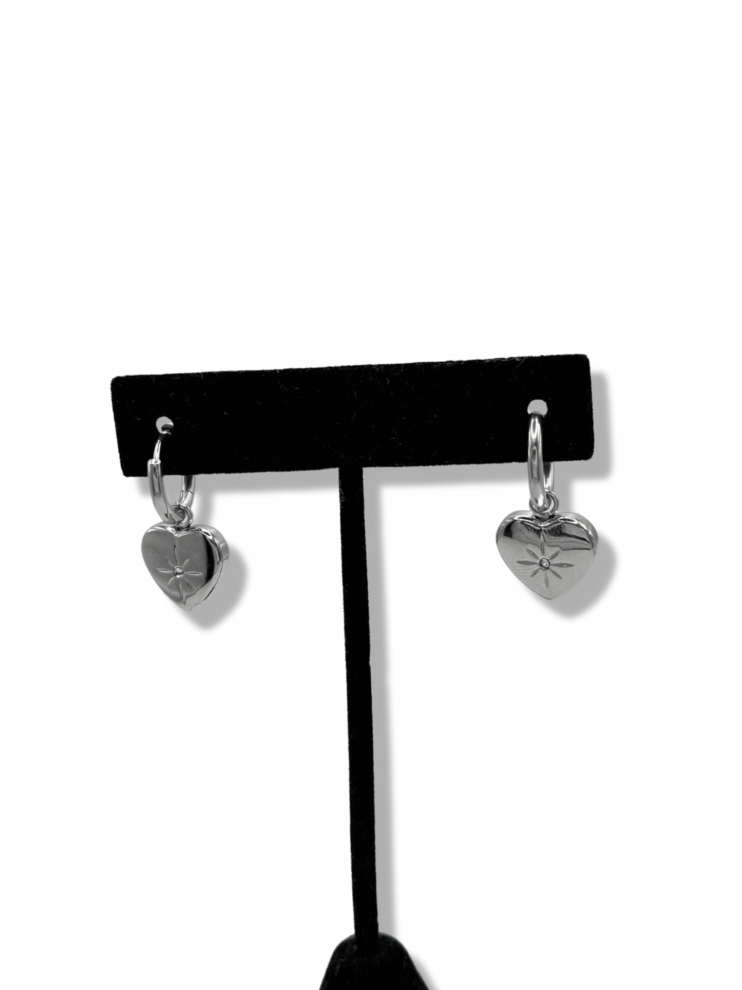 small huggie hoops with a heart pendant. on the heart pendant is an engraved star and rhinestone in the centre