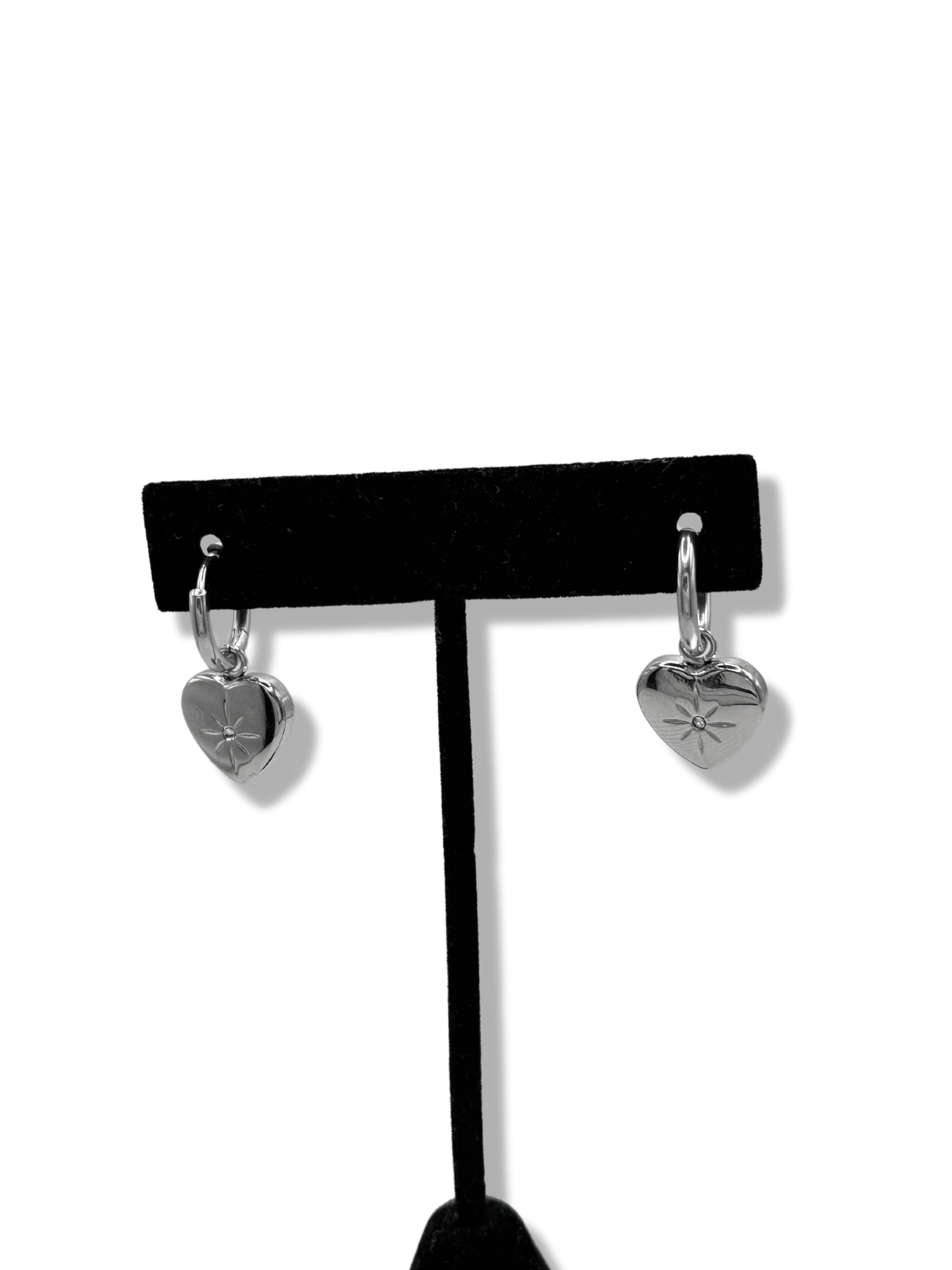 small huggie hoops with a heart pendant. on the heart pendant is an engraved star and rhinestone in the centre