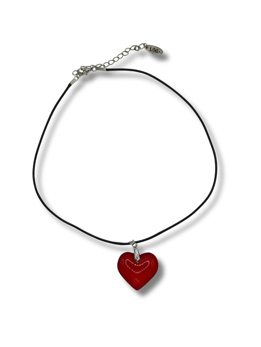 Medium sized red glass heart pendant with silver hardware on a black leather cord chain